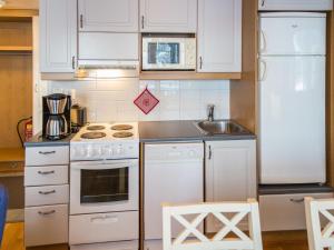 een keuken met witte apparatuur en een witte koelkast bij Holiday Home Point vale 1 ap- 9 by Interhome in Tahkovuori