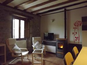 a living room with a fireplace and chairs and a tv at Apartamentos San Francisco 58 in Santo Domingo de la Calzada