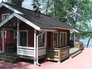 una pequeña casa roja con un porche blanco en Holiday Home Pernoo 1 by Interhome en Pernoo