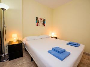 sypialnia z dużym białym łóżkiem z niebieskimi ręcznikami w obiekcie Apartment Vila Olimpica Sant Marti - Sardenya by Interhome w Barcelonie