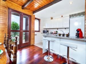 Fogás de TorderaにあるHoliday Home Irisada by Interhomeの白いキャビネットと木製の天井が備わるキッチン