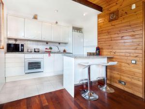 Fogás de TorderaにあるHoliday Home Irisada by Interhomeの白いキャビネットと木製の壁が備わるキッチン