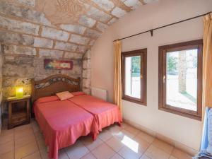 a bedroom with a red bed and a window at Villa Les Mines by Interhome in Selva