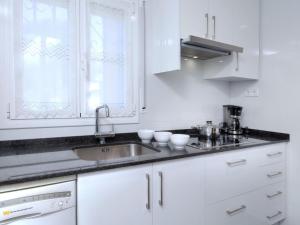 ミアミ・プラトーヤにあるVilla Villa Mar by Interhomeの白いキャビネットとシンク付きのキッチン