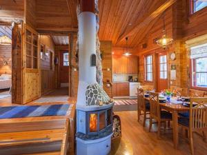 a living room with a fireplace in a log cabin at Holiday Home Riutankolo by Interhome in Lipinlahti