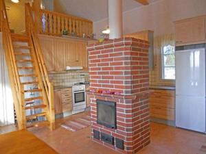a brick fireplace in the middle of a kitchen at Holiday Home Vauvila by Interhome in Kyynämäki