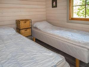 twee bedden in een kamer met een raam bij Holiday Home Lomasyväri 806 by Interhome in Tahkovuori