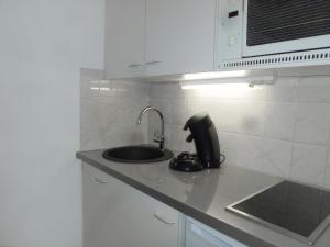 une cuisine avec un évier et un téléphone sur un comptoir dans l'établissement Apartment l'Amiral by Interhome, à Trouville-sur-Mer