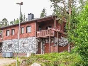 uma grande casa de madeira com um alpendre e uma varanda em Holiday Home Kärpänrinne b by Interhome em Syöte
