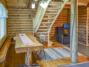 uma sala de jantar com uma mesa e escadas num chalé de madeira em Holiday Home Leporanta by Interhome em Herttuala