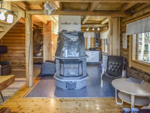 a living room with a fireplace in a log cabin at Holiday Home Leporanta by Interhome in Herttuala