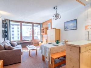 eine Küche und ein Wohnzimmer mit einem Sofa und einem Tisch in der Unterkunft Studio Le Prariond-9 by Interhome in Tignes