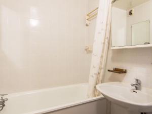 ein weißes Badezimmer mit einem Waschbecken und einer Badewanne in der Unterkunft Studio Le Prariond-9 by Interhome in Tignes