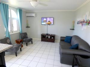 uma sala de estar com um sofá e duas cadeiras em Beach One Bedroom Suite A17 em Ocho Rios