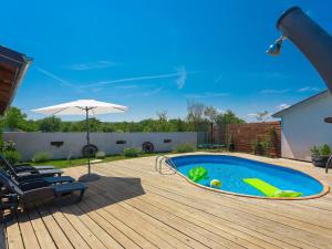 a swimming pool with an umbrella on a wooden deck at Holiday Home Stefanina by Interhome in Labin