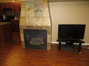 a living room with a fireplace and a tv at Village Creek Country Inn in Westerose
