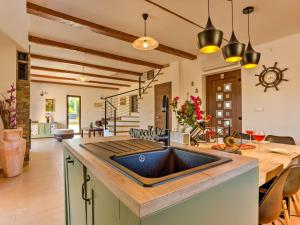a kitchen with a sink and a table with chairs at Holiday Home Villa Willheim in Sveti Ivan Dobrinjski