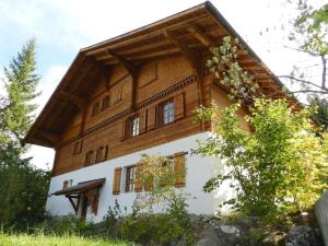 a house with a wooden roof on top of it at Apartment Zapfe - Küenzi by Interhome in Saanenmöser