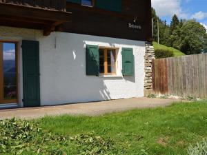 グスタードにあるApartment Rehweid - EG by Interhomeの緑のシャッターと窓のある小さな家