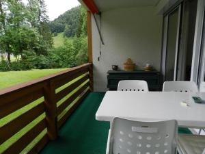 een witte tafel en stoelen op een balkon met uitzicht bij Apartment La Sarine 124 by Interhome in Gstaad