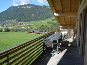 a balcony with a table and chairs on a house at Apartment Alpha by Interhome in Zweisimmen