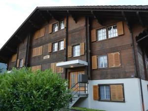 een groot houten gebouw met ramen en een trap bij Apartment Résidence Sonnegg - Herrli by Interhome in Zweisimmen