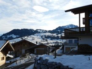 a snow covered village with mountains in the background at Apartment Gletscherblick- Chalet by Interhome in Zweisimmen