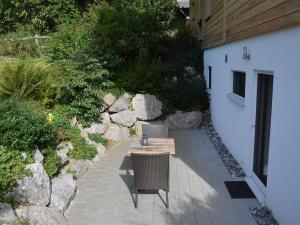 einen Holztisch und zwei Stühle auf einer Terrasse in der Unterkunft Apartment Bolzli-Hus by Interhome in Blankenburg