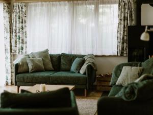 a living room with a green couch in front of a window at Apartment Bärggeist by Interhome in Adelboden