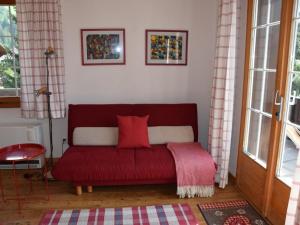レンクにあるApartment Elena # 1 by Interhomeの窓付きの客室で、赤いソファが備わります。