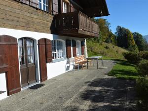 un banco situado fuera de un edificio con balcón en Apartment La Ruche- Chalet by Interhome, en Gstaad