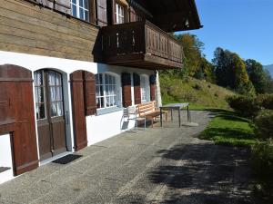 a bench sitting outside of a building with a balcony at Apartment La Ruche- Chalet by Interhome in Gstaad