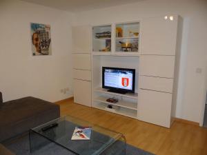 una sala de estar con TV en un centro de entretenimiento blanco en Apartment Neuschwändi 66 by Interhome, en Engelberg