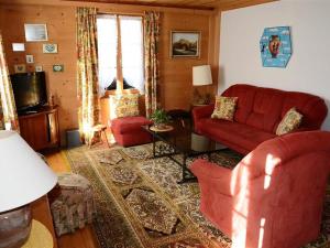 グスタードにあるApartment Margrit by Interhomeのリビングルーム(赤いソファ、テレビ付)