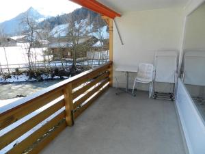 a balcony with two chairs and a table and a window at Apartment La Sarine 212 by Interhome in Gstaad