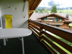 a balcony with a table and a view of a house at Apartment La Sarine 324 by Interhome in Gstaad