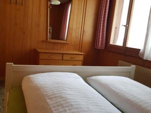 a bedroom with a bed and a dresser and a mirror at Apartment Bodehus by Interhome in Adelboden
