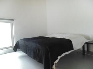 a bedroom with a black and white bed with a window at Holiday Home Bbrik-1 by Interhome in Hoge Seine