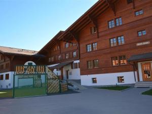een groot houten gebouw met een poort ervoor bij Apartment Henry - 1- Stock by Interhome in Gstaad