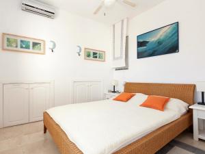 デニアにあるApartment La Marina by Interhomeのベッドルーム1室(白いシーツとオレンジの枕が備わるベッド1台付)