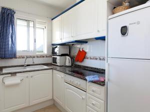 デニアにあるApartment La Marina by Interhomeのキッチン(白いキャビネット、白い冷蔵庫付)
