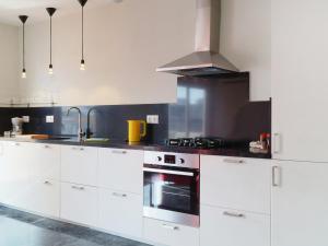 cocina con armarios blancos y fogones en Apartment Plaza de las Flores by Interhome, en Estepona