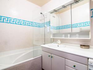 Un baño blanco con lavabo y ducha. en Apartment Galiote-10 by Interhome, en La Foux