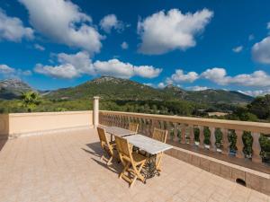 een tafel en stoelen op een balkon met uitzicht op de bergen bij Holiday Home Sa Coma de Campanet by Interhome in Campanet