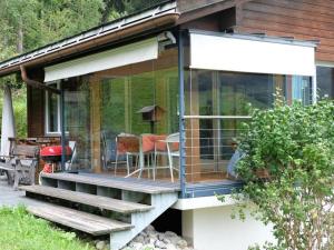 a glass house with a deck and a table at Apartment Weidli- Chalet by Interhome in Zweisimmen