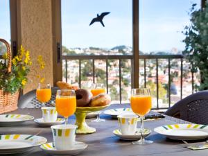 a table with glasses of orange juice and a basket of bread at Apartment Ondina 01 in La Canuta