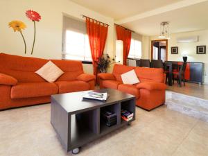 salon z pomarańczowymi kanapami i stołem w obiekcie Holiday Home Aida by Interhome w mieście Palamós