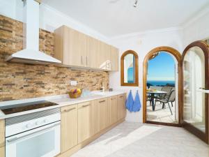 cocina con armarios de madera y vistas al océano en Villa Villa Kalmias by Interhome, en Cumbre del Sol