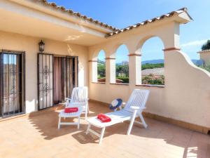 2 weiße Stühle auf einer Terrasse mit Fenstern in der Unterkunft Holiday Home Origami by Interhome in Calonge