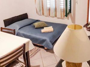 a bedroom with a bed and a table and a lamp at Apartment Dijana-1 by Interhome in Prigradica